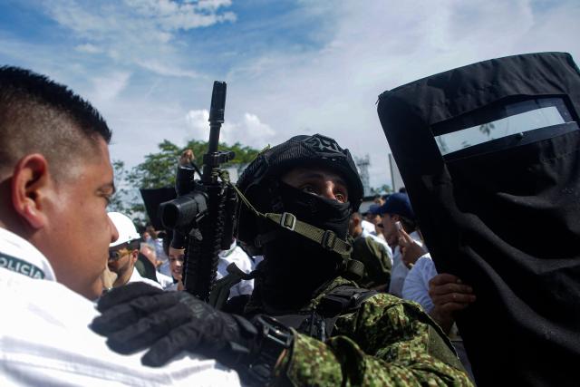 Colombian security forces secure the perimeter during a visit by Colombia's President Abelardo de la Espriella to a damaged house following a 7.4-magnitude earthquake in Buenaventura, Valle del Cauca department, Colombia, on August 24, 2026. (Photo by Cesar QUEIROZ / AFP)