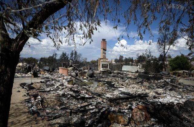 A burned home smolders after it was destroyed by the Hawk fire in Reno, Nevada on August 24, 2026. Tens of thousands of people looked set to spend another night away from home on August 24 as a wind-driven fire bore down on the western US city of Reno. Schools were shuttered as smoke swathed the city in Nevada, near the California border, home to around 280,000 people.
Around 24,000 were still under evacuation orders on Monday, officials said, down from over 40,000 at its peak. (Photo by Josh Edelson / AFP)