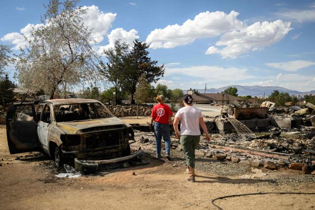 Residents check what's left of their properties burned by the Hawk Fire in Reno, Nevada on August 24, 2026. Tens of thousands of people looked set to spend another night away from home on August 24 as a wind-driven fire bore down on the western US city of Reno. Schools were shuttered as smoke swathed the city in Nevada, near the California border, home to around 280,000 people.
Around 24,000 were still under evacuation orders on Monday, officials said, down from over 40,000 at its peak. (Photo by Josh Edelson / AFP)