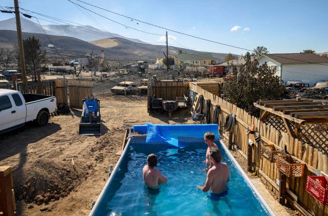 Residents watch the burned homes of their neighborhood while swimming in a backyard pool after they were destroyed by the Hawk Fire in Reno, Nevada on August 24, 2026. Tens of thousands of people looked set to spend another night away from home on August 24 as a wind-driven fire bore down on the western US city of Reno. Schools were shuttered as smoke swathed the city in Nevada, near the California border, home to around 280,000 people.
Around 24,000 were still under evacuation orders on Monday, officials said, down from over 40,000 at its peak. (Photo by Josh Edelson / AFP)