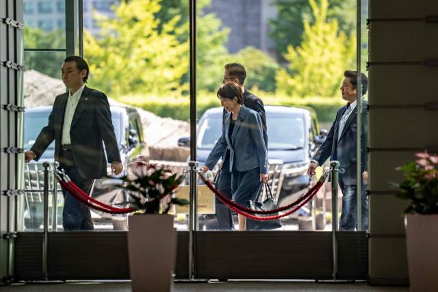 Japan's Prime Minister Sanae Takaichi (C) arrives at the Prime Minister's office in Tokyo on August 25, 2026. (Photo by Yuichi YAMAZAKI / AFP)