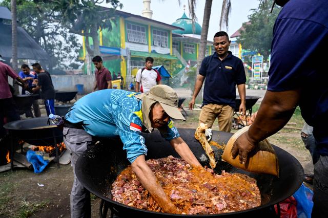 Men prepare traditional curry dishes for residents to mark the birthday of the Prophet Mohammad, in Banda Aceh on August 25, 2026. (Photo by CHAIDEER MAHYUDDIN / AFP)