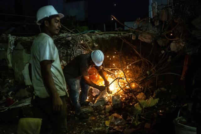A worker cuts metal rods with an angle grinder clearing the rubble of a damaged building 14 days after the 7.4-magnitude earthquake in Pereira, Colombia on August 24, 2026. The powerful earthquake that killed hundreds of people in western Colombia on August 10, 2026, caused $9.57 billion in economic losses, President Abelardo de la Espriella said on August 18, issuing a preliminary estimate. The death toll stands at 289, with a further 4,187 injured and 143 missing. (Photo by ESTEBAN VEGA LA-ROTTA / AFP)