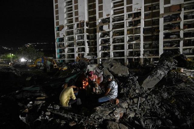 People light candles amid the rubble of a collapsed building from the state-run OPP housing blocks two months after the 7.2 and 7.5-magnitude earthquakes in La Guaira, Venezuela on August 24, 2026. The magnitude 7.2 and 7.5 tremors on June 24, 2026, devastated the coastal state of La Guaira, where at least 190 buildings fell apart. Venezuela's interim government reported 6,509 deaths on August 24, 2026, exactly two months after the twin earthquakes. (Photo by Maryorin Mendez / AFP)