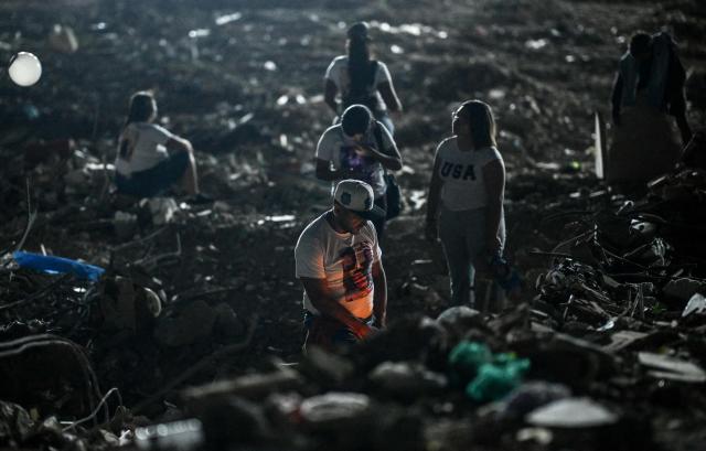 People light candles amid the rubble of a collapsed building from the state-run OPP housing blocks two months after the 7.2 and 7.5-magnitude earthquakes in La Guaira, Venezuela on August 24, 2026. The magnitude 7.2 and 7.5 tremors on June 24, 2026, devastated the coastal state of La Guaira, where at least 190 buildings fell apart. Venezuela's interim government reported 6,509 deaths on August 24, 2026, exactly two months after the twin earthquakes. (Photo by Maryorin Mendez / AFP)