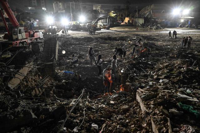 People light candles amid the rubble of a collapsed building from the state-run OPP housing blocks two months after the 7.2 and 7.5-magnitude earthquakes in La Guaira, Venezuela on August 24, 2026. The magnitude 7.2 and 7.5 tremors on June 24, 2026, devastated the coastal state of La Guaira, where at least 190 buildings fell apart. Venezuela's interim government reported 6,509 deaths on August 24, 2026, exactly two months after the twin earthquakes. (Photo by Maryorin Mendez / AFP)