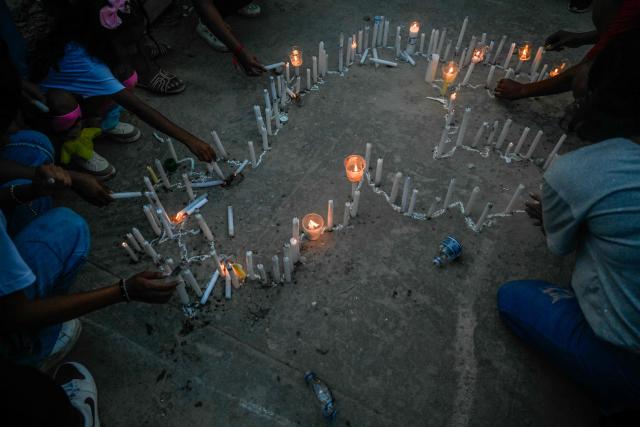 People light candles in the shape of Venezuela next to a collapsed building from the state-run OPP housing blocks two months after the 7.2 and 7.5-magnitude earthquakes in La Guaira, Venezuela on August 24, 2026. The magnitude 7.2 and 7.5 tremors on June 24, 2026, devastated the coastal state of La Guaira, where at least 190 buildings fell apart. Venezuela's interim government reported 6,509 deaths on August 24, 2026, exactly two months after the twin earthquakes. (Photo by Maryorin Mendez / AFP)