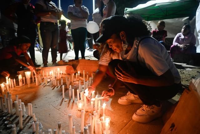 People light candles in the shape of Venezuela next to a collapsed building from the state-run OPP housing blocks two months after the 7.2 and 7.5-magnitude earthquakes in La Guaira, Venezuela on August 24, 2026. The magnitude 7.2 and 7.5 tremors on June 24, 2026, devastated the coastal state of La Guaira, where at least 190 buildings fell apart. Venezuela's interim government reported 6,509 deaths on August 24, 2026, exactly two months after the twin earthquakes. (Photo by Maryorin Mendez / AFP)