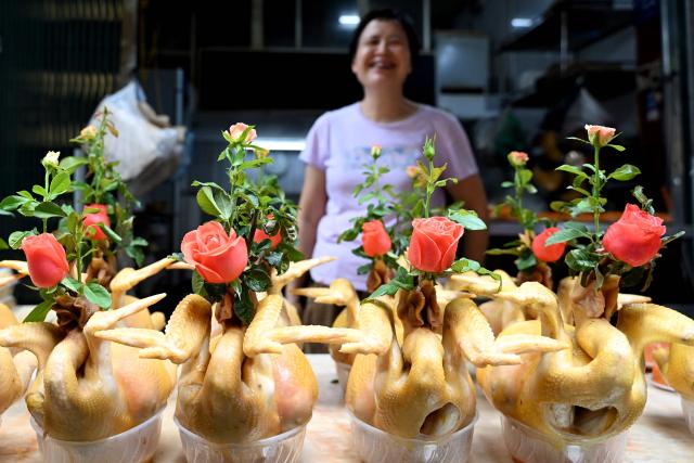A cooked boiled chicken vendor waits for customers at her shop in Hanoi on August 25, 2026. (Photo by Nhac NGUYEN / AFP)