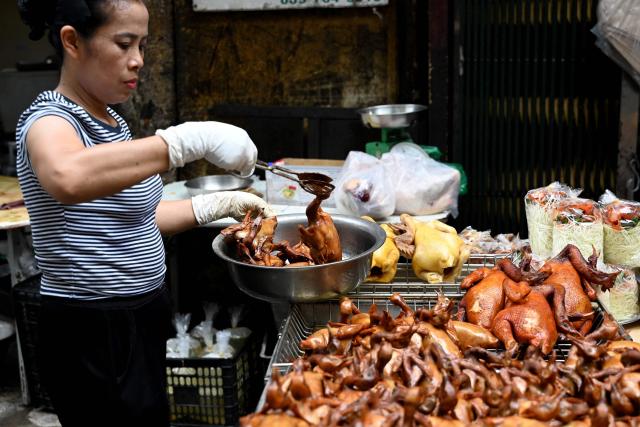 A vendor arranges roasted pigeons for sale at a shop in Hanoi on August 25, 2026. (Photo by Nhac NGUYEN / AFP)