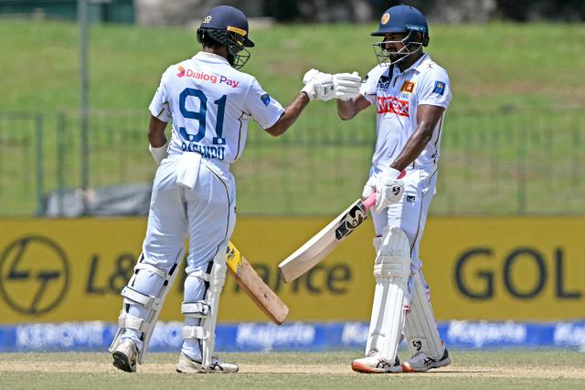 Sri Lanka's Kamindu Mendis (R) and Pasindu Sooriyabandara bump their fists during the third day of the second Test cricket match between Sri Lanka and India at the Sinhalese Sports Club Ground in Colombo on August 25, 2026. (Photo by Ishara S. KODIKARA / AFP)