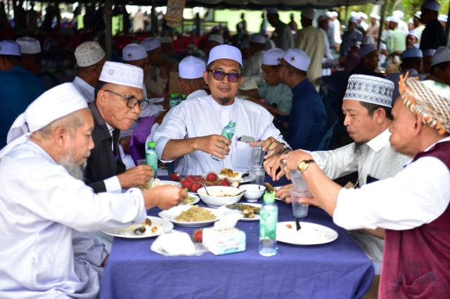 Muslim devotees eat after praying to mark the birthday of the Prophet Muhammad at the Islamic Committee in Thailand's troubled southern Narathiwat province on August 25, 2026. (Photo by Madaree TOHLALA / AFP)