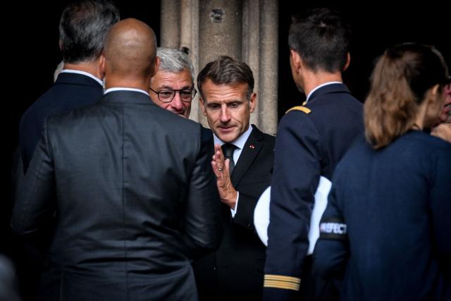 France's President Emmanuel Macron (C) leaves the funeral ceremony of French Senator Francois Patriat, president of the Rassemblement des Democrates, Progressistes et Independants - RDPI (Rally of Democrats, Progressives and Independents) group in the Senate, at the Collegiate Church of Semur-en-Auxois, central France on August 25, 2026. (Photo by OLIVIER CHASSIGNOLE / AFP)