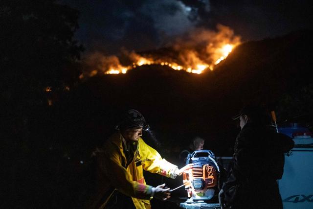 TOPSHOT - Colombian firefighters prepare a blower to battle a wildfire in Coello, Tolima department, Colombia on August 25, 2026. (Photo by ESTEBAN VEGA LA-ROTTA / AFP)