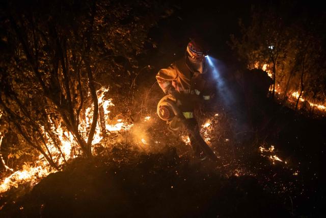 A Colombian firefighter battles a wildfire in Coello, Tolima department, Colombia on August 25, 2026. (Photo by ESTEBAN VEGA LA-ROTTA / AFP)