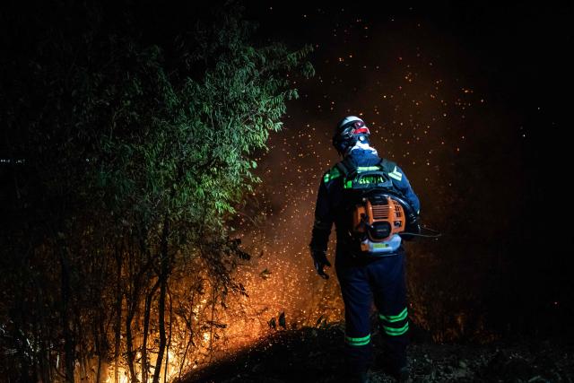A Colombian firefighter battles a wildfire in Coello, Tolima department, Colombia on August 25, 2026. (Photo by ESTEBAN VEGA LA-ROTTA / AFP)