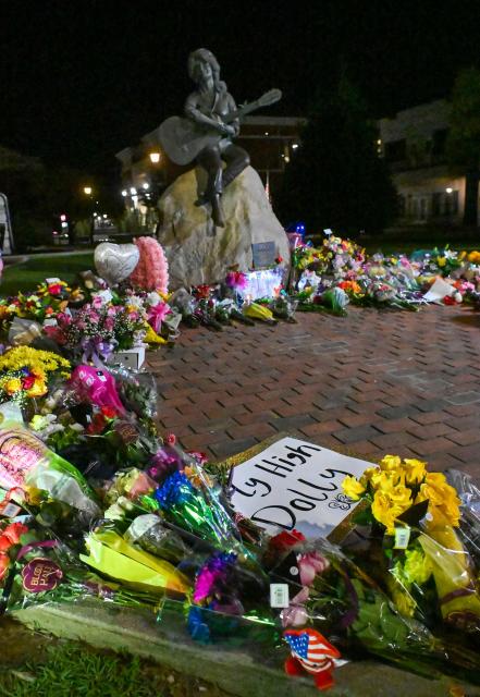 Flowers and notes left by fans are seen by the bronze statue of late US singer-songwriter Dolly Parton in downtown Sevierville, Tennessee on August 25, 2026. Dolly Parton, the American country music singer who rose from poverty in Tennessee to become a US cultural giant with hits like "Jolene" and "9 to 5," has died at 80, her family said on August 25. (Photo by A.M. Stewart / AFP)