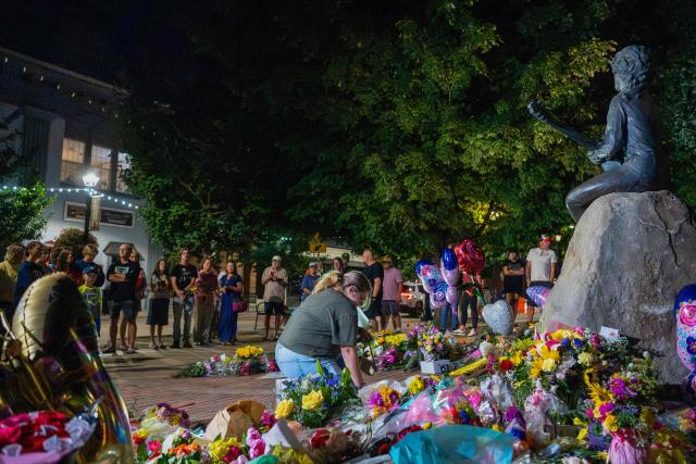 People mourn by the bronze statue of late US singer-songwriter Dolly Parton in downtown Sevierville, Tennessee on August 25, 2026. Dolly Parton, the American country music singer who rose from poverty in Tennessee to become a US cultural giant with hits like "Jolene" and "9 to 5," has died at 80, her family said on August 25. (Photo by A.M. Stewart / AFP)