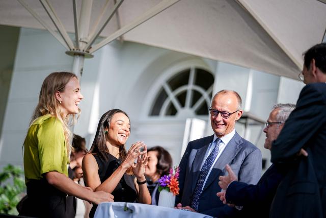 Ruth Bosse (L), CEO and founder of the Ark Climate software start-up, and Judith Dada, co-CEO of Langdock, a leading European AI company, and also Senior Partner at Visionaries Club, an early-stage European venture capital fund, talk with German Chancellor Friedrich Merz on the sidelines of a two day retreat meeting of the German cabinet on August 26, 2026 in Neuhardenberg, northeastern Germany. (Photo by Kay Nietfeld / POOL / AFP)