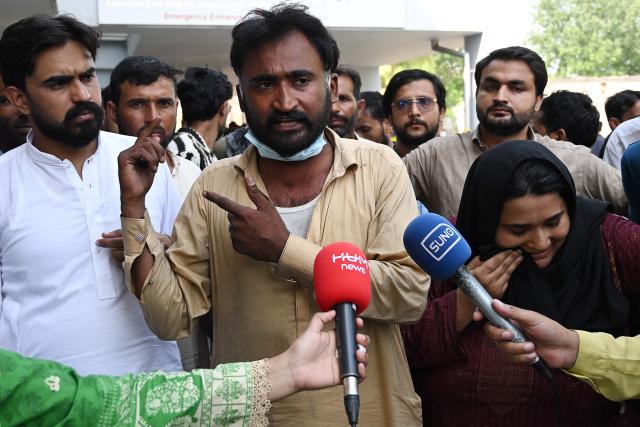 Samiullah (C) and Jaweria (front R), who lost their newborn babies in the fire, speak with media following a blaze at the Mother and Child Health (MCH) ward of the Pakistan Institute of Medical Sciences (PIMS) Hospital in Islamabad on August 26, 2026. A fire in a maternity ward at a public hospital in the Pakistani capital Islamabad on August 26 morning killed 14 children, a local authority said. (Photo by Aamir QURESHI / AFP)