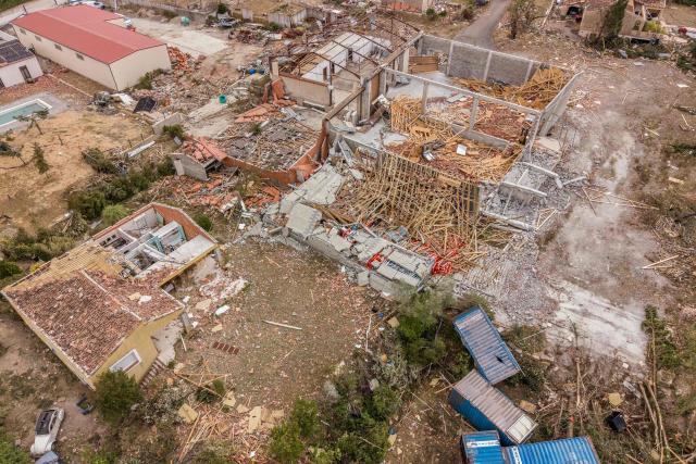 This photograph shows an aerial view of a warehouse destroyed after a tornado in Pomas, southwestern France, on August 26, 2025. Amid the rubble, firefighters, residents, and volunteers were hard at work on Augfust 26, 2026, after a tornado of rare intensity swept through, clearing, securing, and protecting more than 300 damaged houses, 102 of which were destroyed, in the village of Pomas in the Aude département. (Photo by Idriss Bigou-Gilles / AFP)