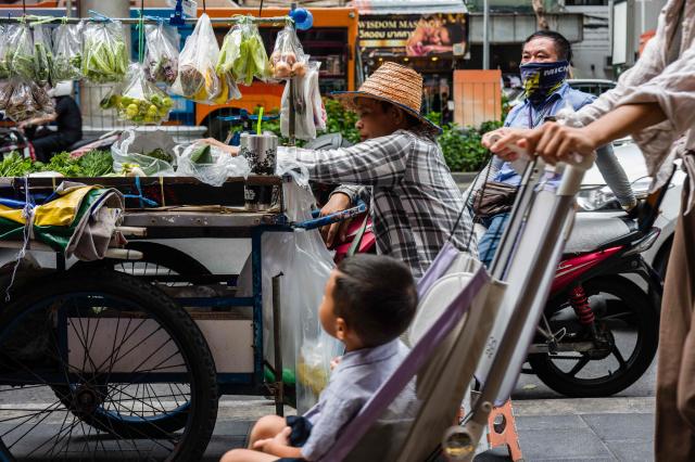 A street food vendor (C) waits for customers at his cart in Bangkok on August 26, 2026. (Photo by ANTHONY WALLACE / AFP)
