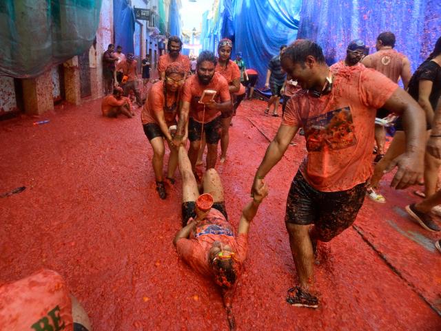 Revellers participate in the "Tomatina" annual food-battle in the Spanish eastern town of Bunol, on August 26, 2026. (Photo by Jose JORDAN / AFP)
