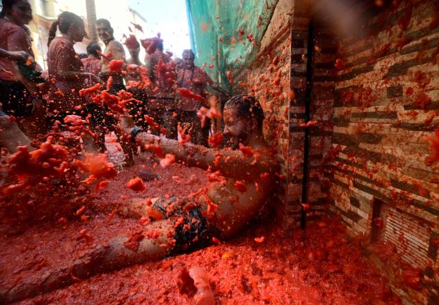Revellers participate in the "Tomatina" annual food-battle in the Spanish eastern town of Bunol, on August 26, 2026. (Photo by Jose JORDAN / AFP)