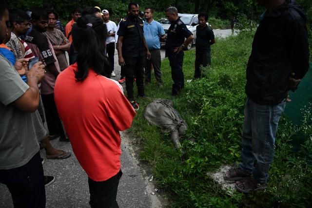 EDITORS NOTE: Graphic content / Residents surround the body of a flood victim following flash floods and a landslide disaster in Devghat, in Nepal's Nuwakot district on August 26, 2026. A massive flood and landslide disaster on the Nepal-Tibet border killed at least 103 people on August 26, 2026 and left several hundred missing, many of them foreign tourists. Aid workers said entire settlements had been "wiped out". Some 403 tourists -- 341 of them foreigners -- were unaccounted for several hours after the disaster struck, according to the tourism ministry. (Photo by PRAKASH MATHEMA / AFP)