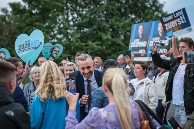 Far-right Alternative for Germany (AfD) party's main candidate Ulrich Siegmund greets supporters as he arrives for a debate on MDR regional TV in Magdeburg, eastern Germany on August 26, 2026. Saxony-Anhalt will go to the polls in the regional elections on September 6, 2026. (Photo by Ronny HARTMANN / AFP)