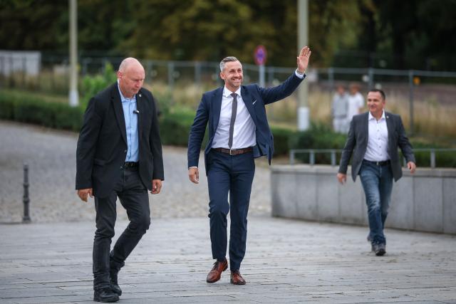 Far-right Alternative for Germany (AfD) party's main candidate Ulrich Siegmund (C) waves to supporters as he arrives for a debate on MDR regional TV in Magdeburg, eastern Germany on August 26, 2026. Saxony-Anhalt will go to the polls in the regional elections on September 6, 2026. (Photo by Ronny HARTMANN / AFP)