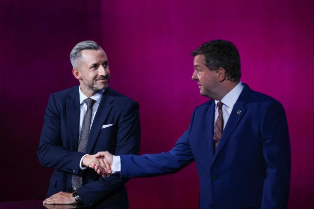 Ulrich Siegmund (L), far-right Alternative for Germany (AfD)'s main candidate in the Saxony-Anhalt state election and Sven Schulze, Saxony-Anhalt's State Premier and Christian Democratic Union's (CDU) main candidate in the Saxony-Anhalt state election shake hand at the start of a head-to-head debate on MDR regional TV in the Broadcasting Center Saxony-Anhalt in Magdeburg, on August 26, 2026, ahead of the upcoming state elections. Saxony-Anhalt will go to the polls in the regional elections on September 6, 2026. (Photo by Ronny HARTMANN / AFP)