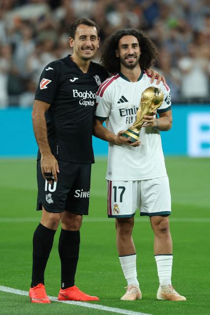 Real Sociedad's Spanish forward #10 Mikel Oiarzabal (L) and Real Madrid's Spanish defender #17 Marc Cucurella, members of Spain's natinal football team that won the World Cup earlier this year, pose together before the start of the Spanish league football match between Real Madrid CF and Real Sociedad  at Santiago Bernabeu Stadium in Madrid on August 26, 2026. (Photo by Thomas COEX / AFP)