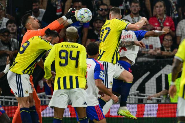 Lyon's Slovak goalkeeper #01 Dominik Greif (L) punches the ball during the UEFA Champions League qualifying playoff - second leg football match between Olympique Lyonnais (OL) and Fenerbahce SK at the Groupama Stadium in Decines-Charpieu, central-eastern France, on August 26, 2026. (Photo by OLIVIER CHASSIGNOLE / AFP)