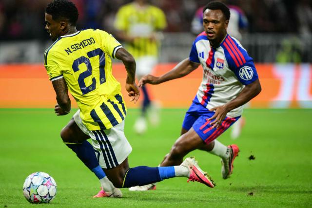 Fenerbahce's Portuguese #27 Nelson Semedo (L) fights for the ball with Lyon's Belgian forward #17 Lois Openda (R) during the UEFA Champions League qualifying playoff - second leg football match between Olympique Lyonnais (OL) and Fenerbahce SK at the Groupama Stadium in Decines-Charpieu, central-eastern France, on August 26, 2026. (Photo by OLIVIER CHASSIGNOLE / AFP)