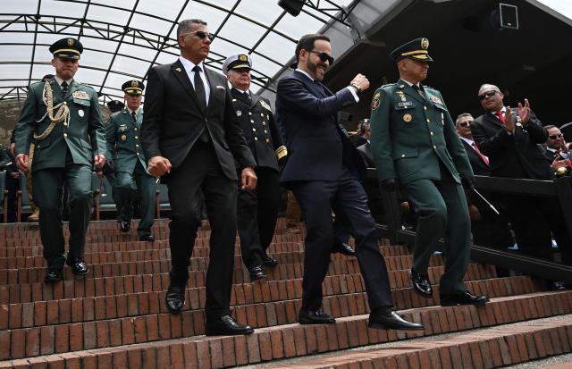 Colombia's President Abelardo de la Espriella (C) and his Defense Minister Jorge Mora (2nd L) descend from the stands to receive military honors during the change of command ceremony at the Jose Maria Cordova Military School in Bogota on August 26, 2026. Colombia's new hard-right government announced on August 25, 2026, plans to classify guerrilla fighters, drug traffickers and other criminal groups as "terrorists." (Photo by Raul ARBOLEDA / AFP)