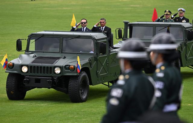 Colombia's President Abelardo de la Espriella (L) and his Defense Minister Jorge Mora receive military honors during the change of command ceremony at the Jose Maria Cordova Military School in Bogota on August 26, 2026. Colombia's new hard-right government announced on August 25, 2026, plans to classify guerrilla fighters, drug traffickers and other criminal groups as "terrorists." (Photo by Raul ARBOLEDA / AFP)
