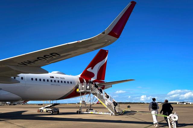 This photo taken on August 25, 2026 shows passengers boarding a Qantas Airlines Airbus A321-XLR aircraft at Mackay Airport in northern Queensland. (Photo by DAVID GRAY / AFP)