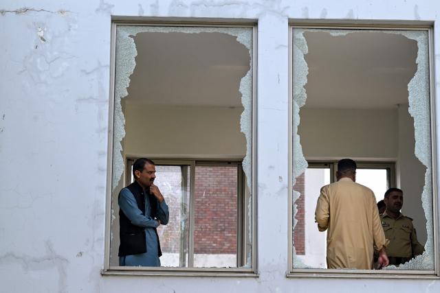 Security personnel stand in a damaged corridor at the site, a day after a fire at the Mother and Child Health ward of the Pakistan Institute of Medical Sciences (PIMS) Hospital in Islamabad on August 27, 2026. A fire erupted in a hospital maternity ward in Islamabad on August 26 killing 14 infants, Pakistan authorities said, blaming a faulty air conditioner for the blaze. (Photo by Aamir QURESHI / AFP)
