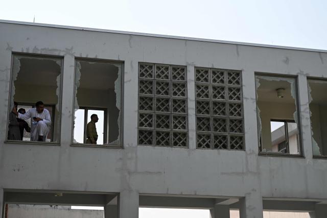 Security personnel stand in a damaged corridor at the site, a day after a fire at the Mother and Child Health ward of the Pakistan Institute of Medical Sciences (PIMS) Hospital in Islamabad on August 27, 2026. A fire erupted in a hospital maternity ward in Islamabad on August 26 killing 14 infants, Pakistan authorities said, blaming a faulty air conditioner for the blaze. (Photo by Aamir QURESHI / AFP)