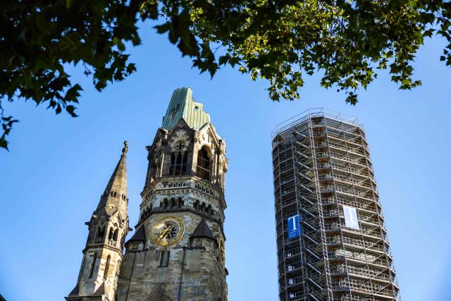 Outside view of the Kaiser Wilhelm Memorial Church (Kaiser-Wilhelm-Gedächtniskirche) that was not rebuilt as a reminder of World War II, with its modern belfry in a scaffolding, in Berlin on August 27, 2026. The Kaiser Wilhelm Memorial Church in Berlin is to undergo renovation over the next three years at a cost of around 40 million euros. In the historic part of the church, the mosaics will be secured, the exhibition renewed, and the ruined tower made accessible to visitors, as Arne Herz, chairman of the Kaiser Wilhelm Memorial Church Foundation, announced. In the adjacent buildings from the 1960s, the concrete honeycomb structures and the blue glass windows, among other things, will be refurbished. (Photo by Odd ANDERSEN / AFP)