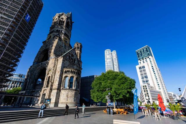 Outside view of the Kaiser Wilhelm Memorial Church (Kaiser-Wilhelm-Gedächtniskirche) that was not rebuilt as a reminder of World War II, with its modern belfry (L) in a scaffolding, in Berlin on August 27, 2026. The Kaiser Wilhelm Memorial Church in Berlin is to undergo renovation over the next three years at a cost of around 40 million euros. In the historic part of the church, the mosaics will be secured, the exhibition renewed, and the ruined tower made accessible to visitors, as Arne Herz, chairman of the Kaiser Wilhelm Memorial Church Foundation, announced. In the adjacent buildings from the 1960s, the concrete honeycomb structures and the blue glass windows, among other things, will be refurbished. (Photo by Odd ANDERSEN / AFP)