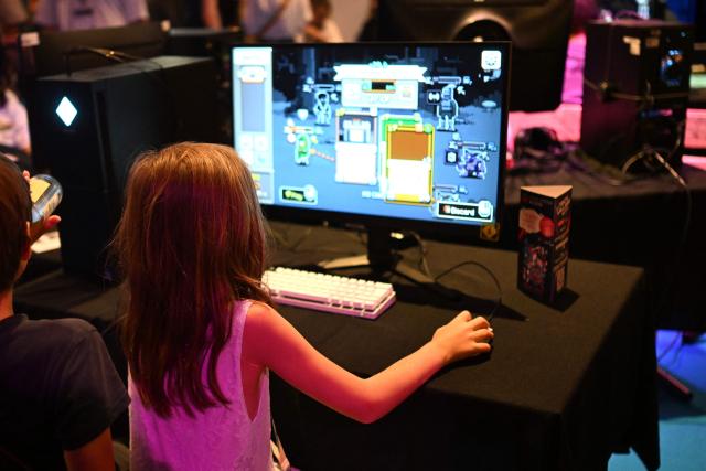 A young girl plays a video game at the Gamescom video games trade fair on the fair grounds in Cologne, western Germany, on August 27, 2026. The 2026 edition of the vast Gamescom trade fair in Cologne, Germany will be running from August 26 to 30, 2026. (Photo by Ina FASSBENDER / AFP)