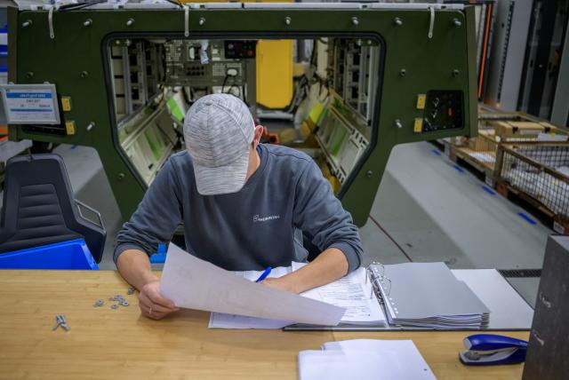 An employee works on documents about the production of the GTK Boxer, an armoured fighting vehicle, on August 27, 2026  in Kassel, western Germany at the premises of German arms manufacturer Rheinmetall. The state of Hesse and Rheinmetall aim to develop northern Hesse as a hub for innovation and defence and economic strength. (Photo by SASCHA SCHUERMANN / AFP)