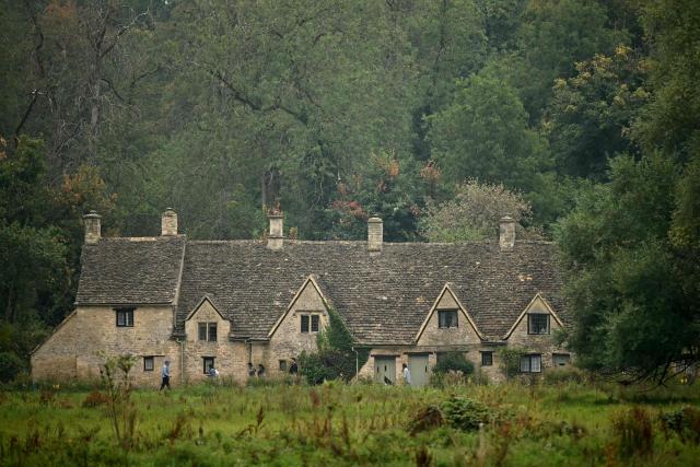 People walk past the Arlington Row Bibury, in a region known as the Cotswolds, north west of London on August 27, 2026. Prince Harry, his wife Meghan and their two children landed August 16 in Britain, UK media reported, after the shock news emerged last week they would be relocating from the United States. The Telegraph reported that the couple plan to stay for "an extended period", living in a home in the Cotswolds region, in central England, having enrolled their children at a school for the coming academic year. (Photo by JUSTIN TALLIS / AFP)