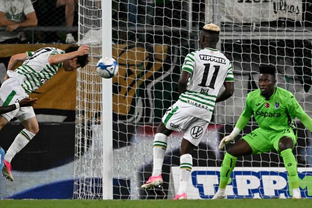 Ferencvaros' Irish midfielder #47 Callum O'Dowda (L) heads the ball to score the opening goal past Trabzonspor's Cameroonian goalkeeper #24 Andre Onana (R) during the UEFA Europa League second leg playoff football match between   Ferencvaros and Trabzonspor in Budapest on August 27, 2026. (Photo by Attila KISBENEDEK / AFP)