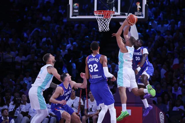 Slovenia's #12 Rok Radovic goes for the basket past France's #00 Sylvain Francisco (R) during the FIBA Basketball World Cup 2027 European Qualifier game between France and Slovenia at the Palais Omnisports de Paris-Bercy, in Paris on August 27, 2026. (Photo by SIMON WOHLFAHRT / AFP)