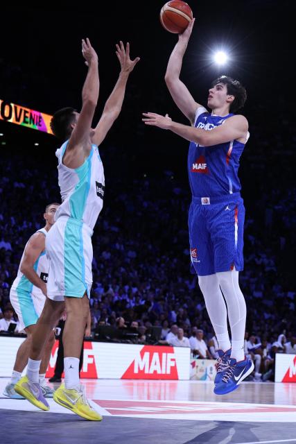 France's #42 Maxime Raynaud (R) goes for the basket past Slovenia's #12 Rok Radovic during the FIBA Basketball World Cup 2027 European Qualifier game between France and Slovenia at the Palais Omnisports de Paris-Bercy, in Paris on August 27, 2026. (Photo by SIMON WOHLFAHRT / AFP)