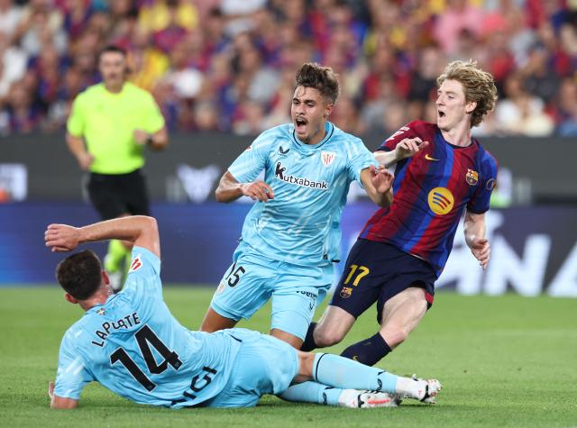 Barcelona's British forward #17 Anthony Gordon fights for the ball with Athletic Bilbao's Spanish defender #14 Aymeric Laporte and Athletic Bilbao's Spanish defender #15 Hugo Rincon Lumbreras during the Spanish league football match between FC Barcelona and Athletic Club Bilbao at Camp Nou Stadium in Barcelona on August 27, 2026. (Photo by Josep LAGO / AFP)
