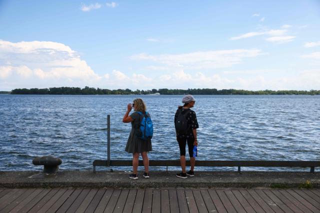 People look out on Lake Ontario from a boardwalk in Toronto, Ontario, on August 27, 2026. US President Donald Trump announced that he is renaming Lake Ontario -- a large body of water shared by the United States and Canada -- "Lake America." Trump signed an order in the White House in a move that comes amid a spiraling trade war between the world's largest economy and its northern neighbor. (Photo by Cole Burston / AFP)
